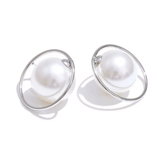 Oversized white pearl stud earrings encircled by a thin silver hoop ring, displayed on white background.