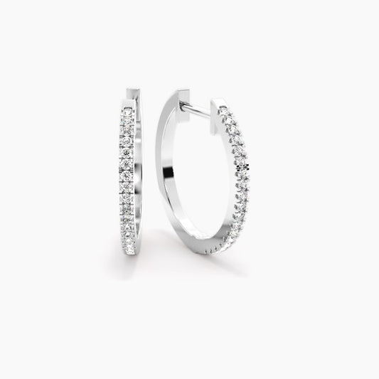 Silver crystal pave huggie hoop earrings with continuous row of sparkling round cut stones and hinged closure, displayed on light background.