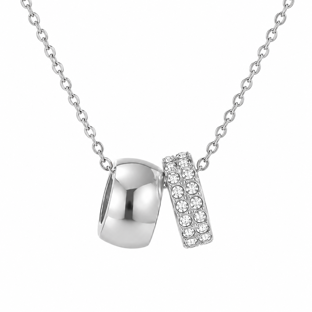 Dainty silver chain necklace with polished silver ring and crystal pave band pendant on white background.