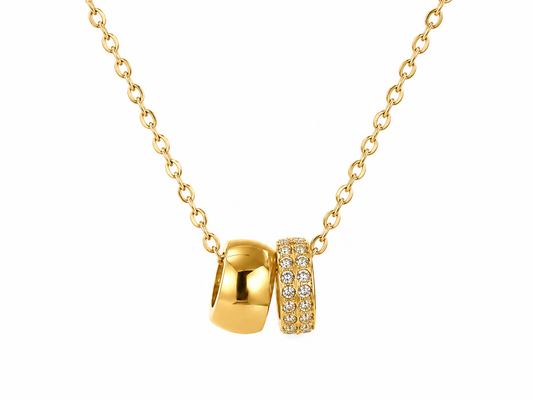 Delicate gold cable chain necklace with smooth gold ring and double row crystal pave band pendant, displayed on white background.
