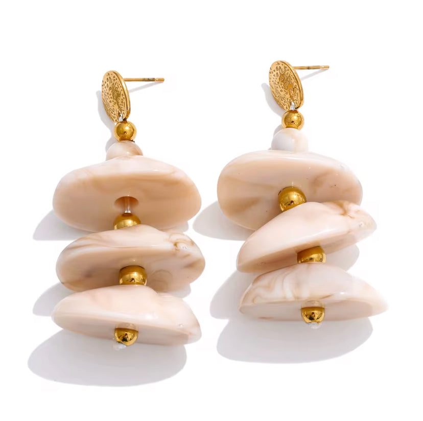 Tiered cream and blush marbled resin drop earrings with gold bead accents and ornate gold coin stud, displayed on white background.
